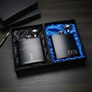 Prabangus dovanų rinkinys: dvi juodos matinės gertuvės (fleškutės) su asmeniniu graviravimu ir piltuvėliais juodose dėžutėse su šilkiniu pamušalu.