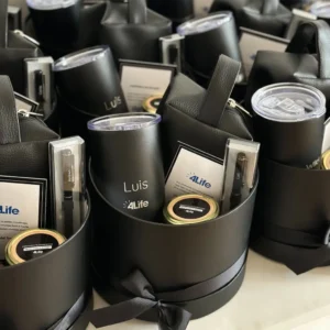 Prabangūs personalizuoti dovanų rinkiniai darbuotojams apvaliose dėžutėse su gertuve, rašikliu ir padėkos kortele.