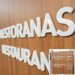 Baltos iškilios 3D raidės ir logotipai iš akrilo, sumontuoti ant lauko informacinio stendo su medžio apdaila, skirti viešbučio ar SPA centro navigacijai ir ženklinimui.