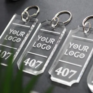 Keturi skirtingų formų skaidraus akrilo raktų pakabukai viešbučiams su išgraviruotu tekstu „Your Logo“ ir kambario numeriu 407