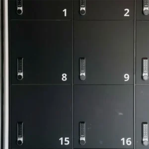 Profesionali lipdukų gamyba: ploteriu pjauti balti vinilo skaičiai spintelių numeracijai ant juodų matinų durelių su elektroninėmis kodinėmis spynomis.