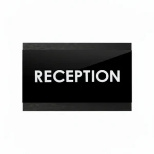 Informacinė lentelė RECEPTION pagaminta iš tamsaus dažyto beržo faneros ir juodo akrilo su iškiliomis baltomis raidėmis.